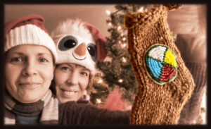 Susan holding up a tree ornament made by her Sister-in-law, with her wife Jenn.